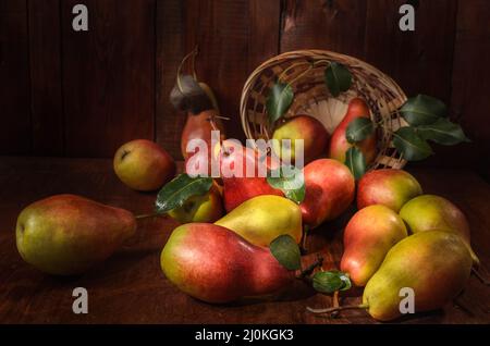 Pere sfuse su sfondo di legno scuro in stile rustico Foto Stock