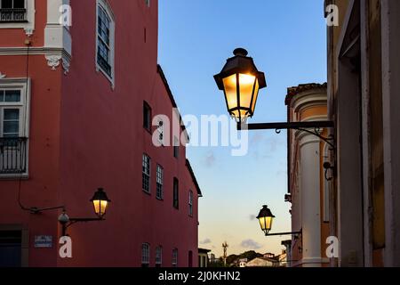 Vecchie lanterne di metallo e facciata di case coloniali nel quartiere storico di Pelourinho Foto Stock