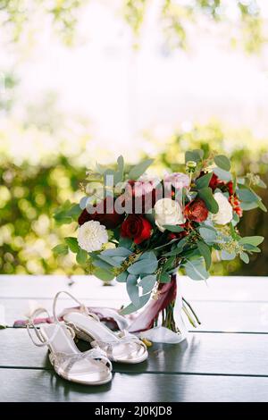 Bouquet nuziale di rose bianche e rosse, peonie, rami di eucalipto, alstroemeria e crisantemo con bianco e maroon r Foto Stock