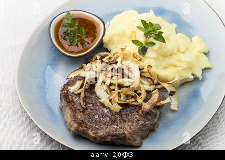 Bistecca con cipolle fritte Foto Stock