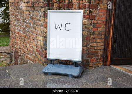 Cartello wc all'ingresso dell'edificio in mattoni Foto Stock