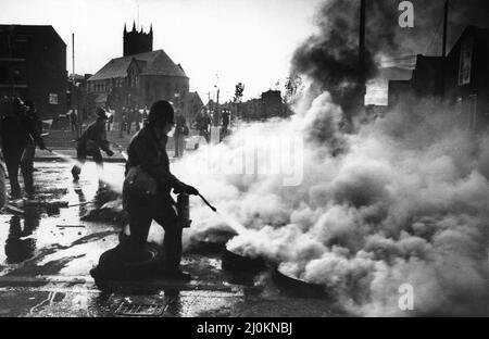 Toxteth Riot 5th luglio 1981Police gli ufficiali armati di estintore tentano di affrontare un blocco stradale di pneumatici in fiamme durante le rivolte Toxteth. Le rivolte sono state innescate a seguito dell'intercettazione da parte della polizia dei motociclisti Leroy Cooper in Selbourne Street. Una folla si riunì, la chiamata di nome crebbe in pochi minuti ci fu un fraas su vasta scala che vide tre poliziotti feriti e un giovane uomo locale, arrestato con accuse d'assalto. Non si è fermata qui. La polizia ha montato pattuglie extra nella zona e all'inizio della sera successiva, 4 luglio, sono venuti sotto attacco da una folla armata di mattoni Foto Stock