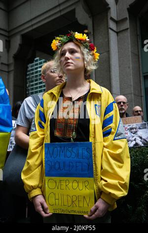 New York, Stati Uniti. 19th Mar 2022. Il protester con i fiori sulla sua testa tiene segno dicendo, 'Nessun missili dovrebbe volare sopra i nostri bambini ' durante il rally. I manifestanti ucraino-americani marciano dall'edificio dell'UNICEF a Times Square in solidarietà con le madri ucraine e chiedono di salvare i loro figli dall'aggressione militare russa. Credit: SOPA Images Limited/Alamy Live News Foto Stock