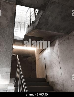 Scala in cemento vuota con corrimano in acciaio all'interno dell'edificio in costruzione Foto Stock