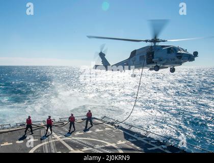 220219-N-EH998-1137 OCEANO ATLANTICO (DAL 19, 2022) i marinai a bordo del cacciatorpediniere missilistico guidato USS Farragut (DDG 99) effettuano un rifornimento in volo con un elicottero MH-60 Sea Hawk, attaccato a Helicopter Maritime Strike Squadron (HSM) 26, mentre sono in corso per Surface Warfare Advanced Tactical Training (SWATT). Farragut fa parte di Destroyer Squadron (DESRON) 26 che supporta Carrier Strike Group (CSG) 10. La SWATT è guidata dal Naval Surface and Mine Warwilling Development Center (SMWDC) ed è progettata per aumentare le capacità di lotta alla guerra, la letalità e l'interoperabilità delle unità partecipanti. ( Foto Stock