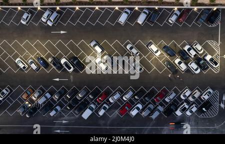 Vista aerea del drone dei parcheggi con auto di notte. Parcheggio affollato per il centro commerciale. Foto Stock