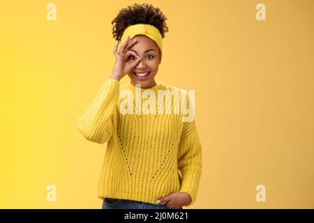 Affascinante tenera ragazza afro-americana show cerchio su occhio ok OK OK gesto guardare fortunato felicemente sorridente imp soddisfatto Foto Stock