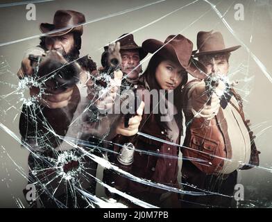 Questo schermo in vetro non ti protegge. Studio girato di una banda di fuorilegge in piedi con le loro pistole puntate dopo aver girato attraverso il tuo schermo di vetro. Foto Stock