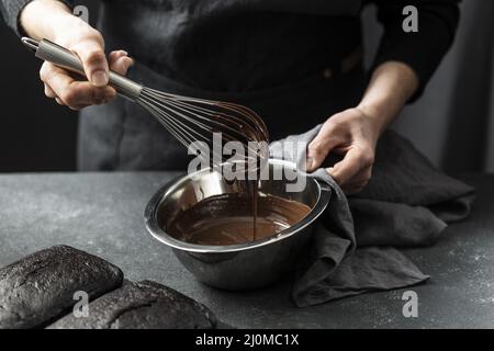 Chef pasticceria ad angolo che prepara la torta al cioccolato Foto Stock