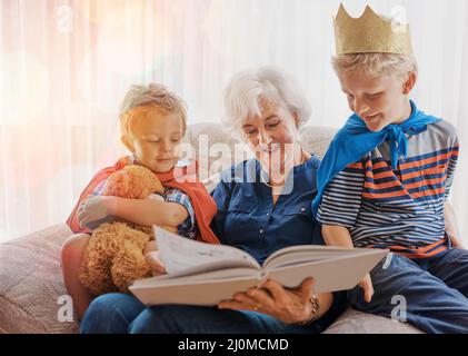 Intrattenimento assicurato. Colpo di una donna anziana che trascorre il tempo a sguastare i suoi nipoti. Foto Stock