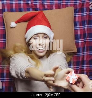 Atmosfera festiva. Lady santa riceve un regalo di Natale. In attesa di Natale. Poster delle festività Foto Stock