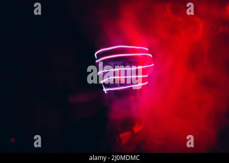 Luce al neon in bicchieri di un uomo. Ritratto futuristico cyber studio.  Techno bagliore e vibrante colore cyberpunk. Modello maschile con occhiali  da sole Foto stock - Alamy