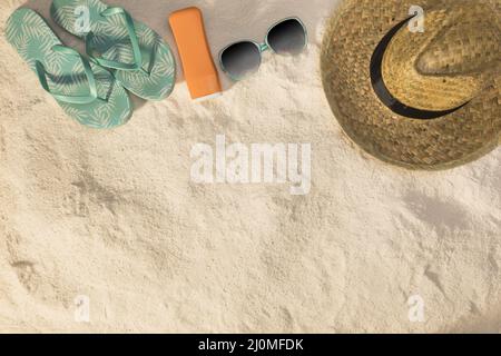 Cappello occhiali da sole sandali blu crema solare sabbia Foto Stock