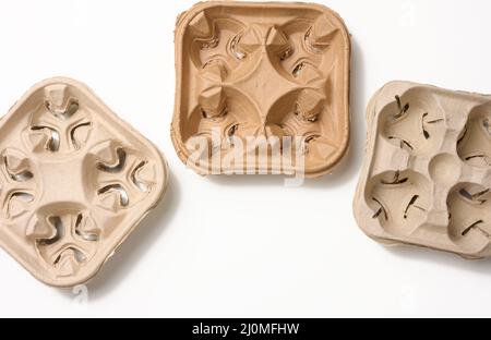 Porta bevande calde riciclabili marrone, porta carta per quattro tazze, sfondo bianco. Zero sprechi Foto Stock