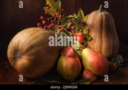 Pere mature e zucca su sfondo di legno scuro in stile rustico Foto Stock
