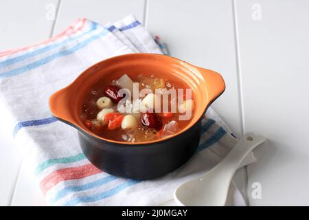 Peach Gum, bevanda tradizionale cinese contiene Peach Gum, Bird Nest, Red Datters, Snow Fungus, Goji Berry, E Rock Sugar. Su tavola bianca Foto Stock