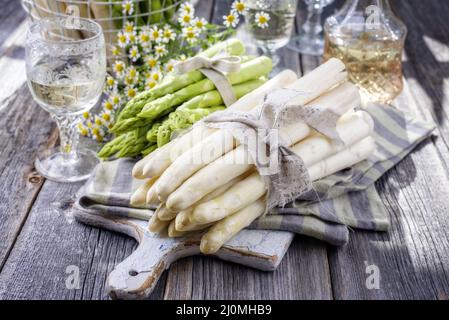 Row verde e bianco Asparagus come primo piano su un tagliere Foto Stock