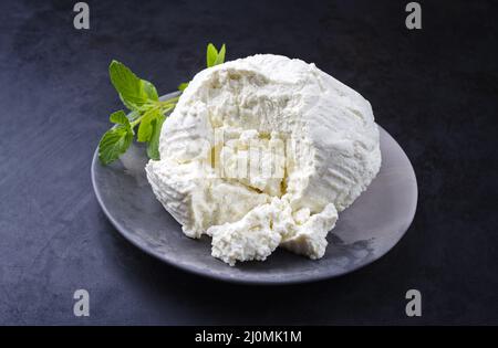 Ricotta fresca italiana con foglie di menta servita da vicino su un moderno piatto di design Foto Stock