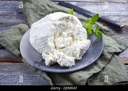 Ricotta fresca italiana con foglie di menta servita da vicino su un moderno piatto di design Foto Stock