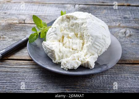 Ricotta fresca italiana con foglie di menta servita da vicino su un moderno piatto di design Foto Stock