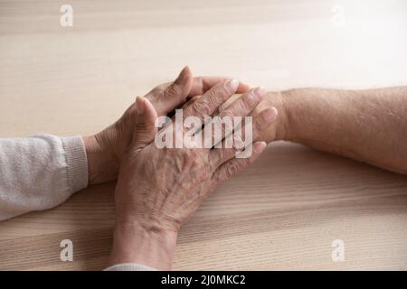 Primo piano la moglie più anziana che tiene la mano del marito Foto Stock