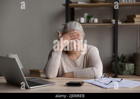 La donna più anziana si sente sollecitata a causa della mancanza di soldi pagare le fatture Foto Stock