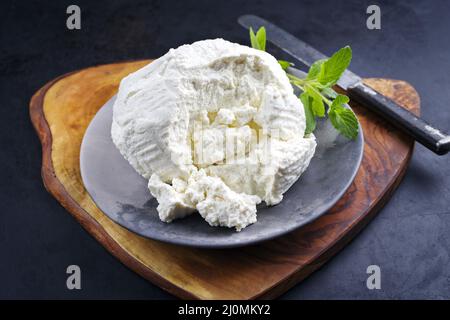 Ricotta fresca italiana con foglie di menta servita da vicino su un moderno piatto di design Foto Stock