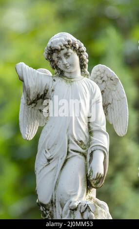Piccolo angelo bianco antico in porcellana spezzata . Figurina in ceramica senza mano destra. Foto Stock