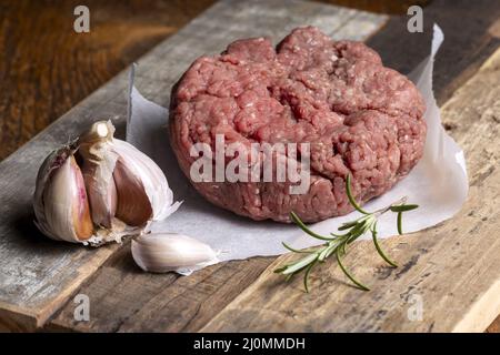 Carne macinata cruda su legno scuro Foto Stock