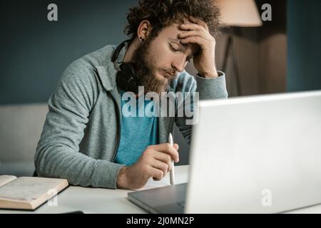 Young Man realizza sul suo notebook un piano aziendale per l'implementazione della sua attività. Manager crea metodi più efficaci per Foto Stock