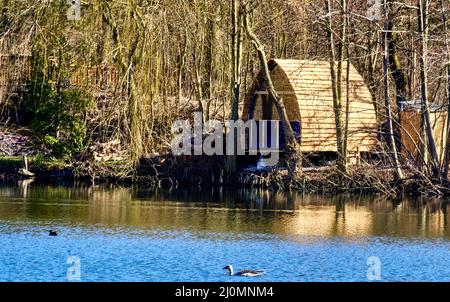 Cottage di legno di recente costruzione su un lago come alloggio per le vacanze o week-end Foto Stock