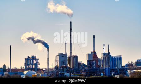 Piccola raffineria con camini da fumo e molti serbatoi di stoccaggio per liquidi Foto Stock