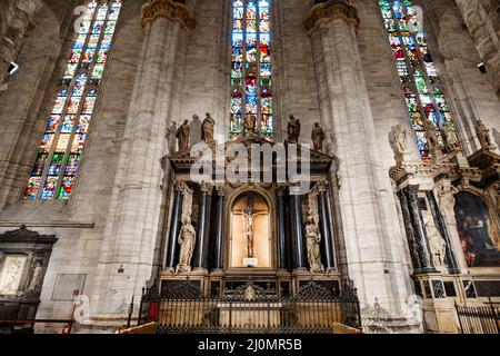 Crocifissione tra statue in vetrata nel Duomo. Milano, Italia Foto Stock