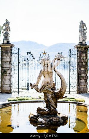 Statua di una sirena nella fontana nel giardino di fronte al cancello. Villa Monastero, Italia Foto Stock