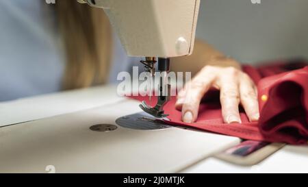 Cucire le mani in primo piano con la macchina Foto Stock