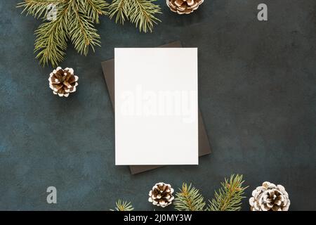 Carta bianca circondata da coni di foglie di pino Foto Stock