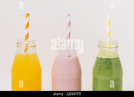 Bottiglie assortite per frullati di frutta deliziosi con paillette Foto Stock