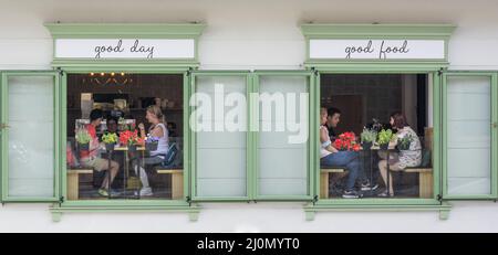 Banska Stiavnica, Slovacchia - Luglio, 31, 2021 : persone all'interno di un ristorante a Banska Stiavnica, vista attraverso le finestre da fuori Foto Stock