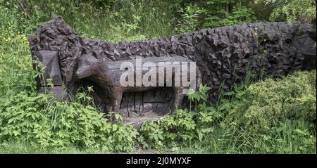Banska Stiavnica, Slovacchia - 6 giugno 2021 : statua scolpita di lupo di legno nel parco. Decorazione del giardino. Scultura. Foto Stock