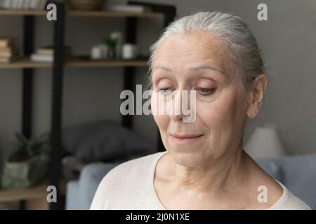 Primo piano volto di una donna anziana sconvolto perso in pensieri tristi Foto Stock