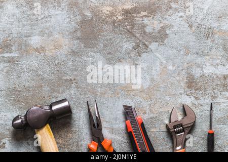 Diversi tipi di utensili da lavoro disposti a fila arrugginita scrivania in legno Foto Stock