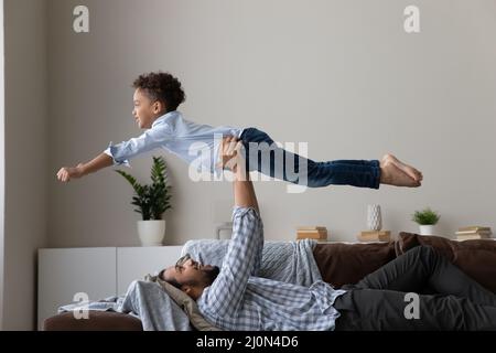 Felice papà africano che gioca a giochi sportivi con un figlio piccolo attivo Foto Stock