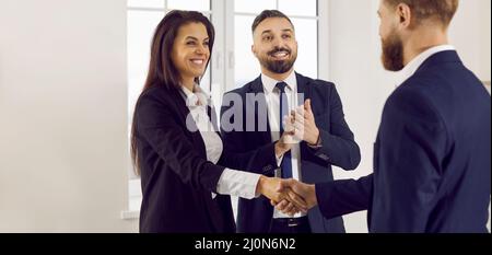 I partner aziendali sorridenti e soddisfatti confermano il loro accordo di successo con la stretta di mano. Foto Stock