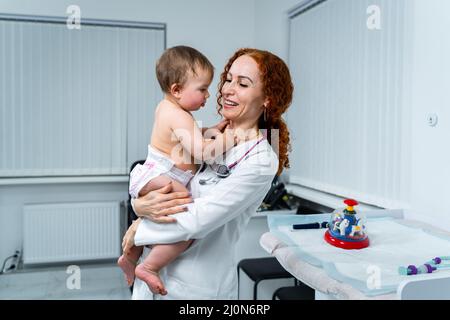 Pediatrician providing healthcare for her baby patient in the office of a specialized clinic for children. Neonatologist. Medica Stock Photo