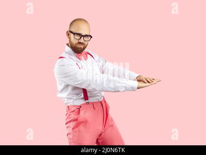 Ritratto di un bel ballerino in occhiali danzanti isolato su uno sfondo rosa studio Foto Stock