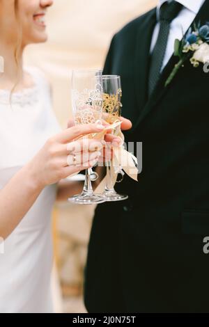 Bride e sposo clink bicchieri di champagne. Primo piano Foto Stock