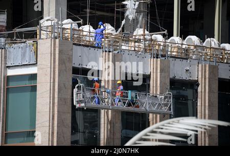 Doha, Qatar. 20th Mar 2022. I lavoratori edili lavorano in un alto edificio nel centro di Doha. Numerose strade e case sono attualmente in fase di riprogettazione nella corsa alla Coppa del mondo. Il Qatar viene ripetutamente criticato per il trattamento riservato ai lavoratori stranieri. Il ministro tedesco dell'economia e della protezione del clima Habeck è in visita di tre giorni nel Golfo Persico. Credit: Bernd von Jutrczenka/dpa/Alamy Live News Foto Stock