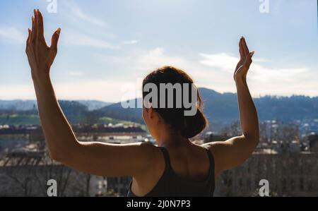 donna che alza le braccia Foto Stock