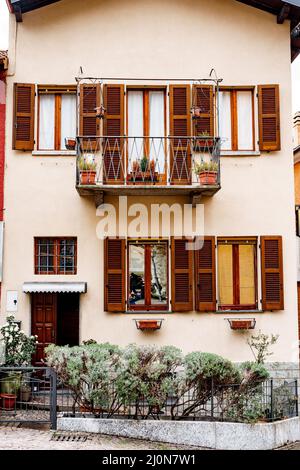 Letto di fiori con cespugli alle porte della vecchia casa di Varenna. Como, Italia Foto Stock