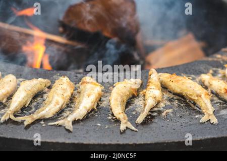 Preparazione tradizionale pesce fritto europeo odore di essere cucinato a fuoco aperto in un mercato di cibo di strada, pronto a mangiare, cibo di strada a Vilnius Foto Stock